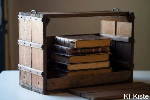 Eine offene hochgestellte altmodische Bücherkiste mit einem Bücherstapel. Im Boden fehlt ein Brett.